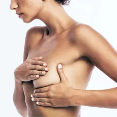 Primo piano di una donna che si tocca il seno, evidenziando la zona dell'areola con i suoi piccoli tubercoli di Montgomery.