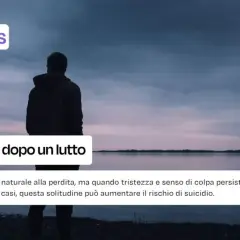 Uomo solo guarda un lago al tramonto, simbolo de la solitudine dopo un lutto. Il cielo è nuvoloso, l'atmosfera malinconica.