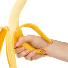 Mano che sbuccia una banana, simbolo di forza e vitalità, in contrasto con la disfunzione erettile.