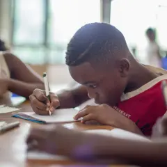 Bambini concentrati sui loro quaderni, alcuni con DSA e ADHD, imparano e scrivono con impegno.