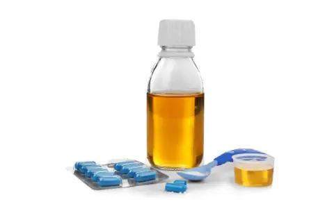 Flacone di sciroppo, blister di pillole blu e misurino con polvere bianca. Per assumere l'antibiotico a stomaco pieno o vuoto, consultare il medico.