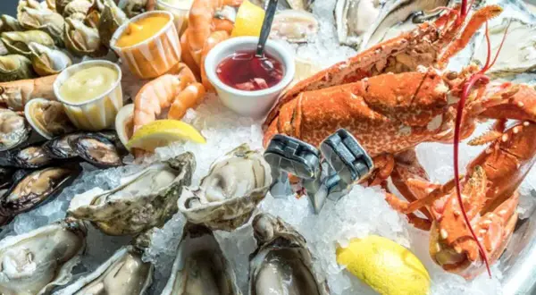 Un vassoio di frutti di mare su ghiaccio, con ostriche, gamberi, aragosta e cozze. Potrebbe scatenare la paura irrazionale di crostacei e molluschi in qualcuno.