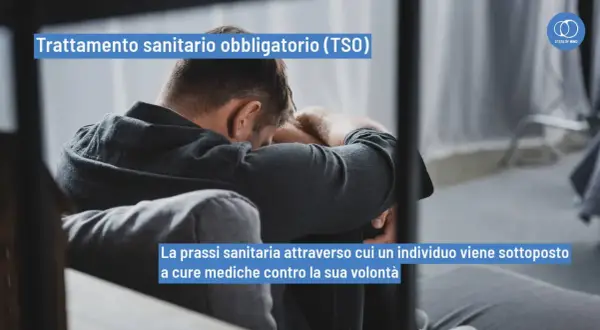 Uomo seduto, testa china, simbolo di un TSO (Trattamento Sanitario Obbligatorio). La prassi sanitaria che impone cure mediche.
