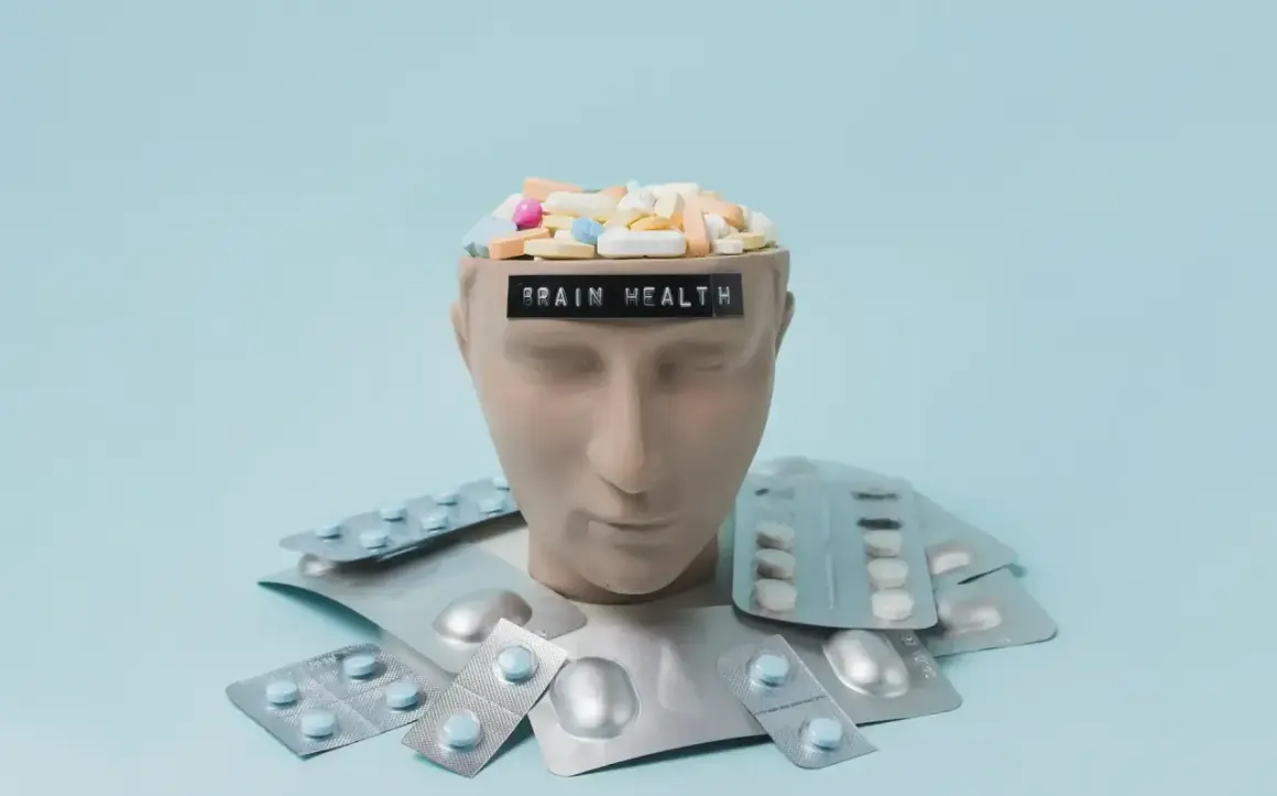 Testa di manichino piena di pillole, con blister intorno. La scritta "BRAIN HEALTH" suggerisce che gli psicofarmaci danneggiano il cervello.