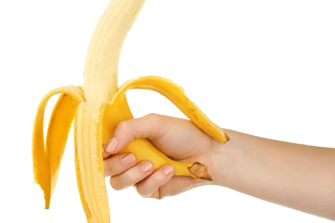 Mano che sbuccia una banana, simbolo di forza e vitalità, in contrasto con la disfunzione erettile.