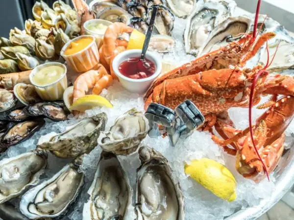 Un vassoio di frutti di mare su ghiaccio, con ostriche, gamberi, aragosta e cozze. Potrebbe scatenare la paura irrazionale di crostacei e molluschi in qualcuno.