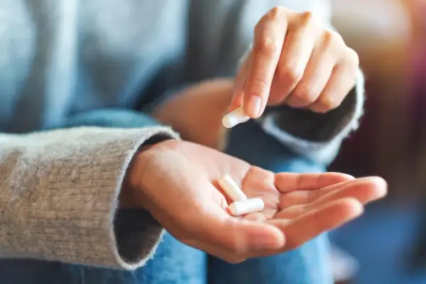 Mano che tiene capsule bianche, per capire diflucan a cosa serve.